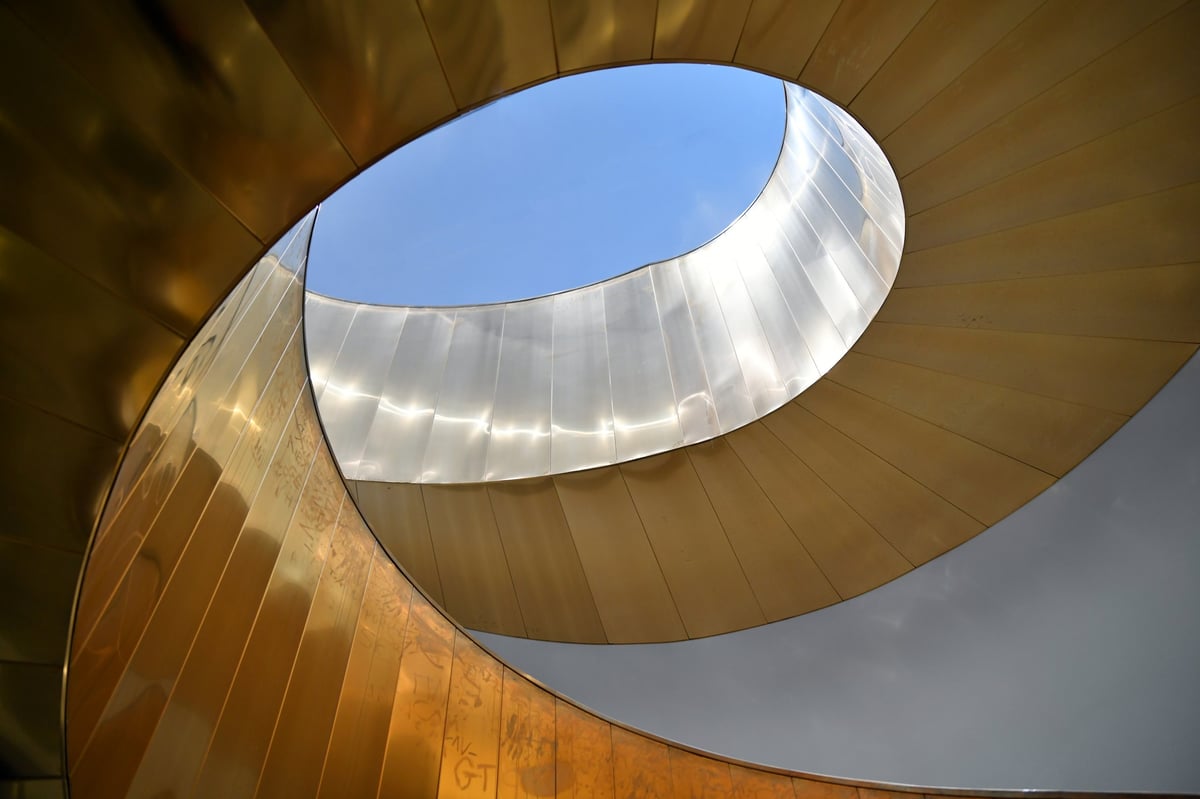 Escalera de caracol helicoidal en tonos gris y dorado